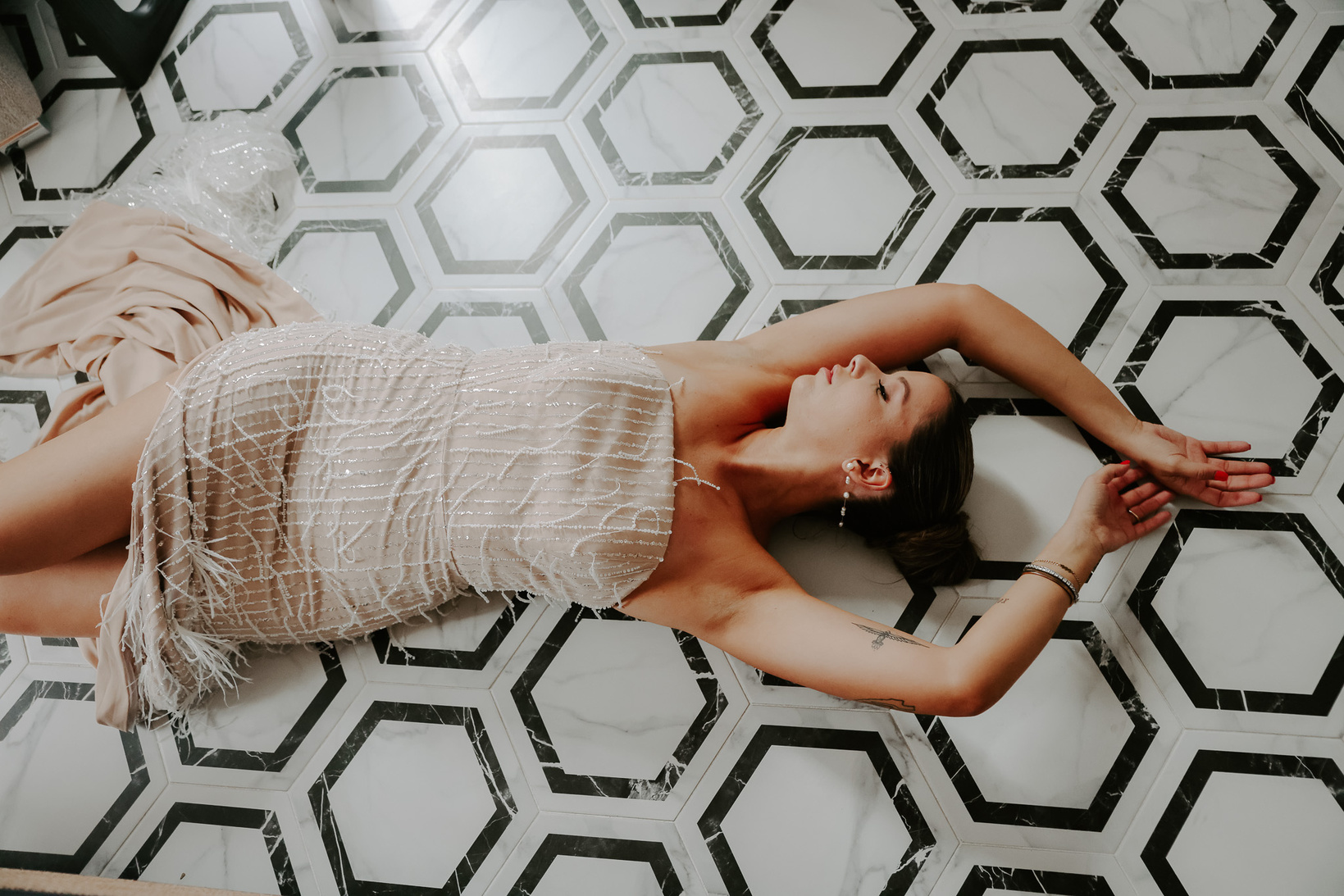 a person in a formal sequin wedding dress laying on the floor